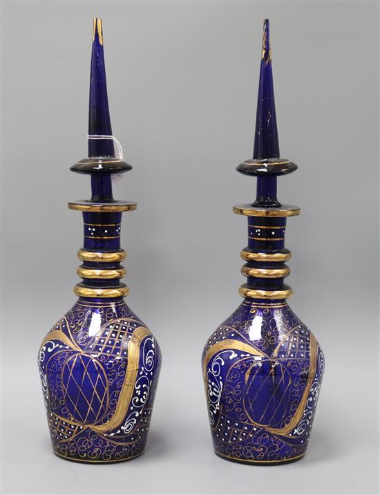 A pair of gilded and enamelled blue glass decanters and stoppers height 48cm